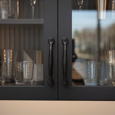 the glass cabinet is full of glasses and silverware