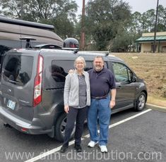 an older couple standing in front of their van