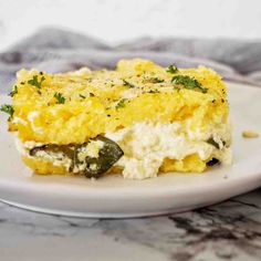 a white plate topped with an egg casserole covered in cheese and green peppers