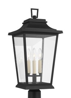 an outdoor light with three lit candles on the front and side of it, against a white background