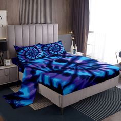 a bed with blue and purple comforters in a bedroom