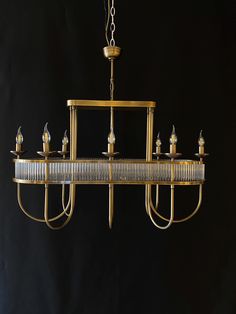 a chandelier hanging from the ceiling in front of a black background with gold trim