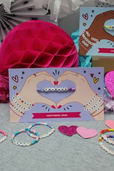 there is a card with two hands making a heart on it next to other cards and decorations