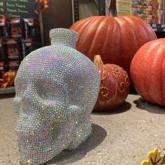 there is a crystal skull next to some pumpkins and other decorations on the counter