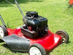 a red lawn mower sitting in the grass