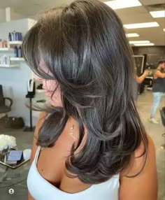 a dark brunette butterfly haircut with curled ends and a bit of volume is a chic and eye catching idea Blowout Hair