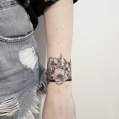 a woman with a black and white flower tattoo on her left arm, holding onto the wrist