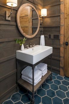 a bathroom sink sitting under a mirror next to a wooden wall mounted faucet