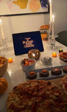 a table topped with lots of pizza and cupcakes