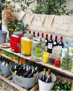 a wooden bench filled with lots of bottles and buckets full of drinks on top of it