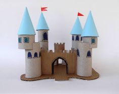 a castle made out of cardboard with red flags on the top and blue roof tops