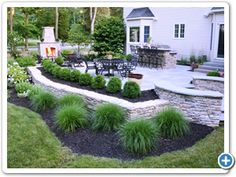 an outdoor patio with stone walls and landscaping