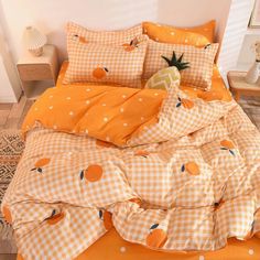 an orange and white checkered comforter set with pineapples on the pillow