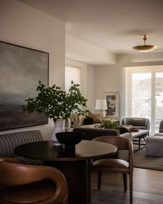 a living room filled with furniture and a painting on the wall