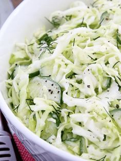 a white bowl filled with cucumber salad on top of a table