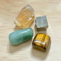 three different colored stones sitting on top of a wooden table