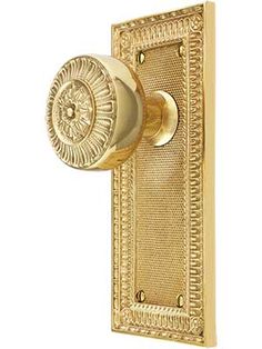 a golden door handle with an intricate design on the front and back side of it