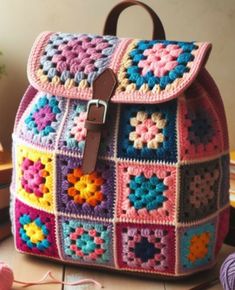 a colorful crocheted backpack sitting on top of a table