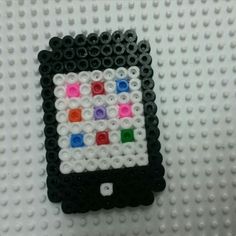 a cell phone made out of legos on a white surface with black, red, green, and blue beads