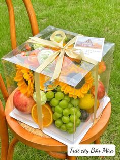 a clear box filled with fruit on top of a wooden chair