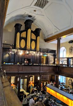 an overhead view of a large building with lots of people sitting at tables and standing in front of the organ