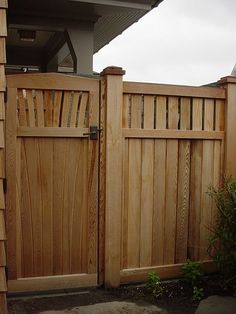 a wooden gate is open in front of a house