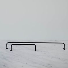 a white marble counter top with black metal bars on the bottom and one bar in the middle