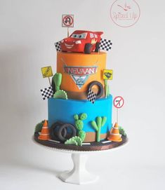 a three tiered cake with cars on it