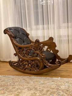 a wooden rocking chair sitting on top of a hard wood floor next to a window