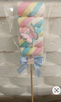 a candy lollipop is wrapped in plastic and tied to a stick with a bow