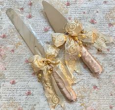 This is a listing for a lovely matching set of a cake cutter & cake server that are embellished with a glittered gold silk wired ribbon & faux pearl sprays in soft gold tones. The cake server handles are wrapped in the softest rose-gold satin ribbon. Please see photos for approximate sizes. Rose Gold Satin, Cake Server Sets, Soft Rose, Gold Satin, Gold Silk, Cake Server, Shower Baby, Wired Ribbon, Party Accessories