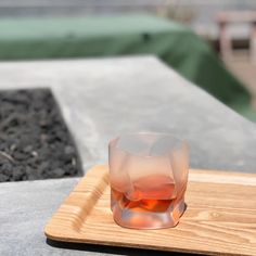 an empty glass sitting on top of a wooden tray