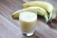 two bananas and a glass of milk on a table