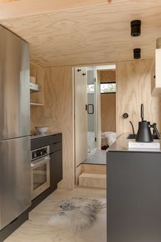 a modern kitchen with stainless steel appliances and wood paneling on the walls is shown