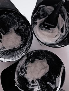 three black and white bowls filled with whipped cream