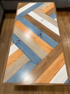 a wooden table with multicolored stripes on it's surface in a living room