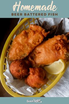 fried fish in a yellow basket with lemon wedges