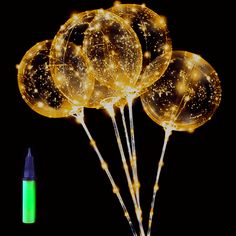 some balloons that are glowing in the dark with lights on them and a green marker next to it