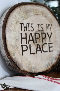 this is my happy place sign on a wood slice with pine cones in the background