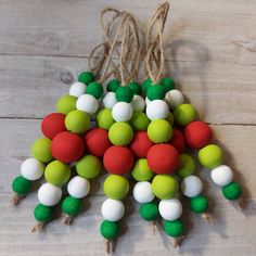 a bunch of green, white and red pom - poms hanging from twine