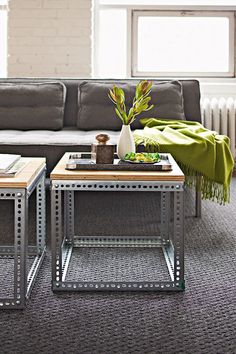 two tables with plants on them in front of a couch and coffee table next to each other