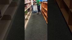 a man is vacuuming the floor in a library