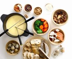 a table topped with bowls filled with different types of food next to an umbrella shaped cheese board