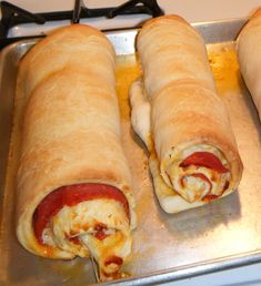 three sausage wrapped in bread sitting on top of a stove