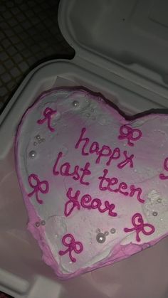 a heart shaped cake with pink frosting on it in a plastic container that says happy last ten years