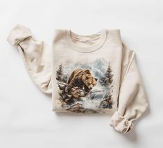 Retro Grizzly Bear Fishing In Creek Sweatshirt - 90s Vintage Brown Bear Alaska Trout Fish Outfit - Boho Unisex Crewneck Sweatshirt   Our crewneck sweatshirts are beautiful, soft, and comfortable midweight sweatshirts. The kind of sweatshirt you won't want to take off, we promise we won't tell if you wear it multiple days in a row! These sweatshirts are hand printed with a professional garment printer known as DTG for a soft, durable, long-lasting, printed graphic using high-quality water-based ECO inks. Gildan is generally the brand we use but sometimes we have to substitute for Jerzees, Port& CO, and Hanes ECO Sweatshirt blanks. depending on supply shortages. All of the brands are equally great sweatshirts that are super soft inside and almost identical in both feel and sizing. Our sweats Wilderness Outfit, Fish Outfit, Alaska Outfits, Bear Fishing, Trout Fish, Horse Sweatshirts, Outfit Boho, Bear Sweater, Cuddling On The Couch