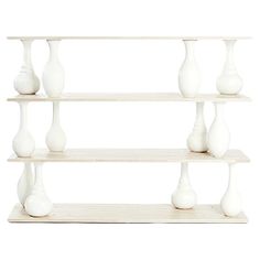 three shelves with white vases on each shelf