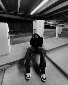 a man sitting on the ground in a parking garage