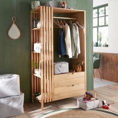 a wooden closet with clothes hanging on it