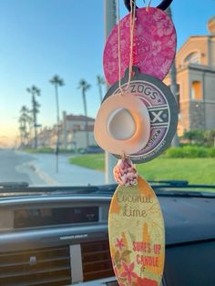 an air freshener hanging from the dashboard of a car in front of a palm tree